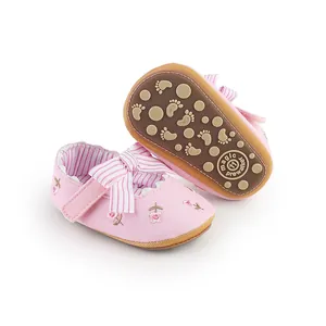 Dettaglio scarpe primi passi rosa a fiori per neonata con fiocco e suola antiscivolo