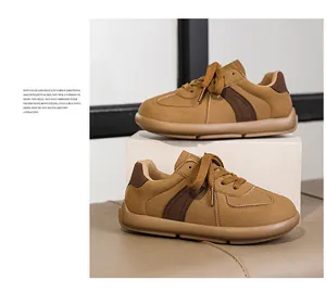 Close-up detail of brown suede retro German army trainer sneakers for women with tan laces.