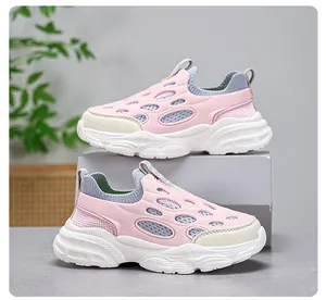 Vista lateral de zapatillas de malla rosa para niños con suelas blancas gruesas.
