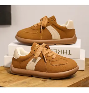 Detailed side view of brown suede retro German training sneakers on decorative white boxes