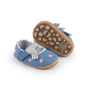 Dettaglio di scarpine da principessa per neonata con ricami floreali e fiocco