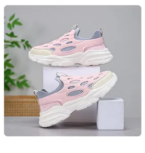 Vista lateral de zapatillas de malla rosa transpirable para niños con suela blanca