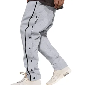 Detalle de pantalones deportivos grises para hombre con rayas laterales y broches
