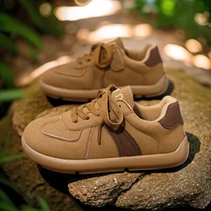 Retro brown women's German Army Trainer sneakers on natural rock, autumn fashion