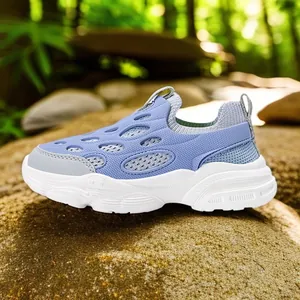 Zapatillas infantiles de malla lavanda sobre una roca de bosque natural