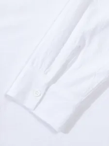 Detailed macro view of a white cotton linen men's shirt cuff with a single button.