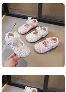 Detalle de los zapatos de princesa brillantes para niña con lazo y detalles de strass