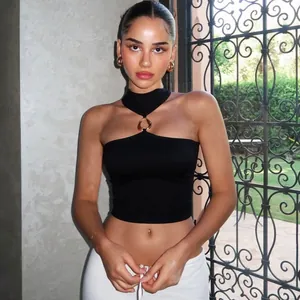 Dettaglio di un crop top allacciato al collo nero con anello in metallo dorato