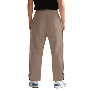 Vista posterior detallada de pantalones de chándal marrones gruesos con botones laterales