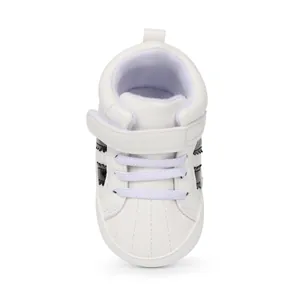 Close-up of white baby high-top sneakers with soft soles and convenient Velcro strap