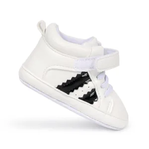 Detailed view of white infant walking shoe with velcro strap and soft sport sole.