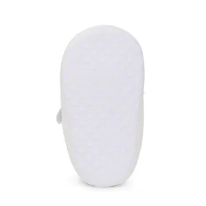 Detailed view of the anti-slip white sole with polka dots for baby walking shoes