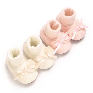 Close-up of pink and cream baby girl bow socks shoes with non-slip soft cotton soles