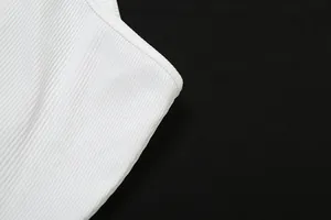 Dettaglio ravvicinato della trama del tessuto a coste bianco di un top a lupetto da donna