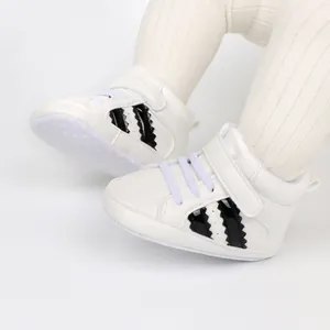 Close-up of white soft-soled high-top baby walking shoes with black stripes design.