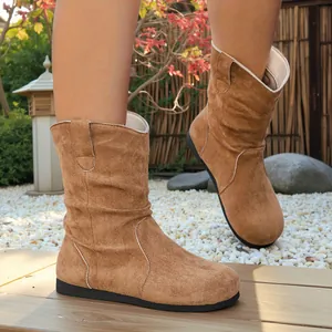 Close-up detail of stylish brown suede slouchy ankle boots with a comfortable flat sole.