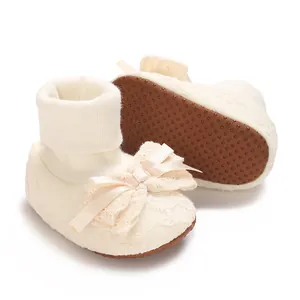 Close-up of newborn girl lace sock shoes with satin bow and anti-slip sole