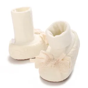 Detailed view of elegant cream baby girl lace socks shoes with decorative ribbon bow