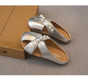 Primer plano de zapatillas de princesa plateadas para niñas con detalles de perlas