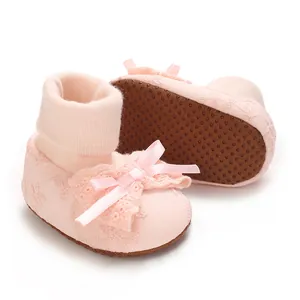 Close-up of pink baby bow socks showing the soft fabric and non-slip dotted sole design