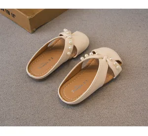 Vista detallada de las elegantes zapatillas de princesa para niñas en blanco crema con perlas