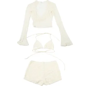 Detail view of white lace three-piece set showing long sleeves, halter top and shorts.