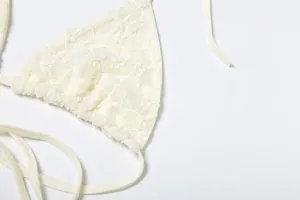 Detailed macro view of the delicate white lace fabric and stitching on a sexy halter top