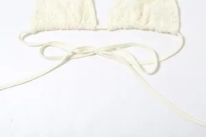 Close-up detail of cream lace halter top showing delicate floral texture and adjustable ties