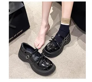 Primer plano de zapatos Mary Jane de charol negro con detalle de lazo y suela gruesa