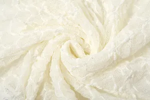 Detailed macro shot of white lace fabric with subtle shimmering sequins and mesh pattern