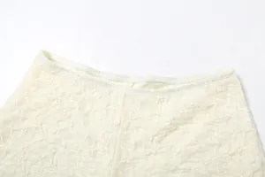 Close-up of the waistband on cream lace shorts showing intricate fabric texture