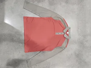 Detailed flat-lay view of a red and gray long-sleeved raglan polo shirt with three-button collar