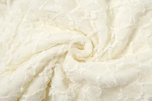 High resolution macro shot of creamy white floral lace fabric with metallic silver glitter