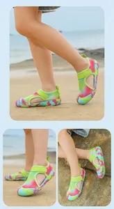 Detail view of kids' breathable mesh water shoes with colorful camouflage soles on beach