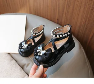 Black patent leather girls shoes with butterfly bow and pearl ankle strap details