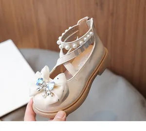 Detail view of beige girls princess shoes featuring pearl straps and a sparkling heart bow