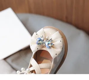 Close-up of a girl's princess shoe featuring a dotted bow and heart-shaped crystals.
