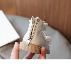 Detailed view of the back zipper on cream white girls' bow princess leather shoes.