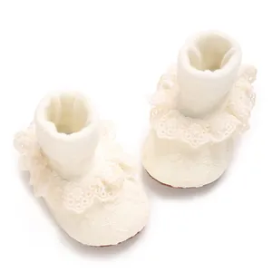 Detalle de calcetines de encaje para bebé con bordados florales y volantes