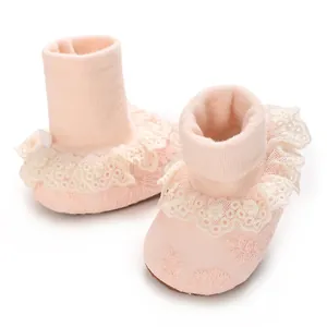 Primer plano de calcetines rosa para bebé con volantes de encaje y bordados