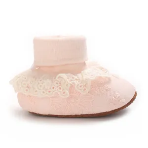 Primer plano de este calcetín zapato rosa para bebé con encaje y bordado floral