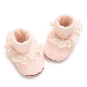 Vista detallada de calcetines rosas para bebé con encaje elegante y bordado floral
