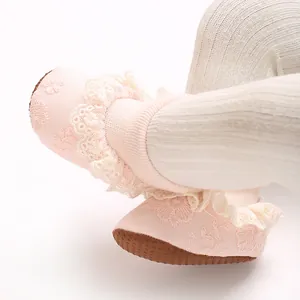 Primer plano de calcetines rosa para bebé con encaje delicado y suelas antideslizantes
