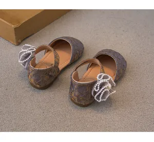 Vista dettagliata di scarpe da principessa per bambina con fiori di perle e pizzo