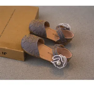 Dettaglio scarpe da principessa per bambina con elegante fiore di perle e trama a rilievo