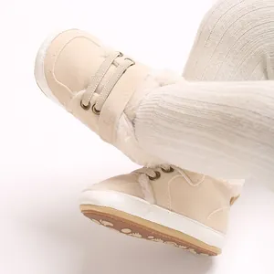 Nahaufnahme warmer beiger Plüsch-Babystiefel mit weichem Fellfutter und Anti-Rutsch-Sohle