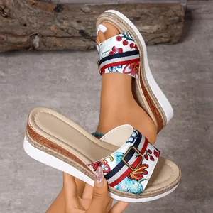 Detailed view of floral embroidered wedge sandals with striped ribbon and buckle.