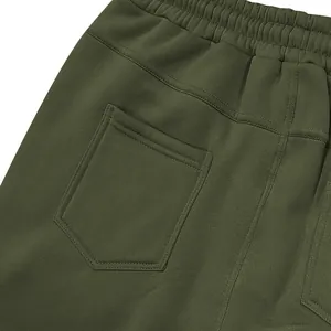 Detailopname van olijfgroene heren cargobroek met elastische taille en achterzaktextuur