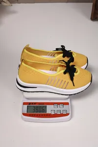 Detailed view of lightweight yellow fly-knit walking shoes weighing 380.6g on a digital scale