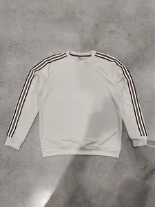 Détail d'un sweat-shirt beige à maille gaufrée pour homme avec des manches rayées